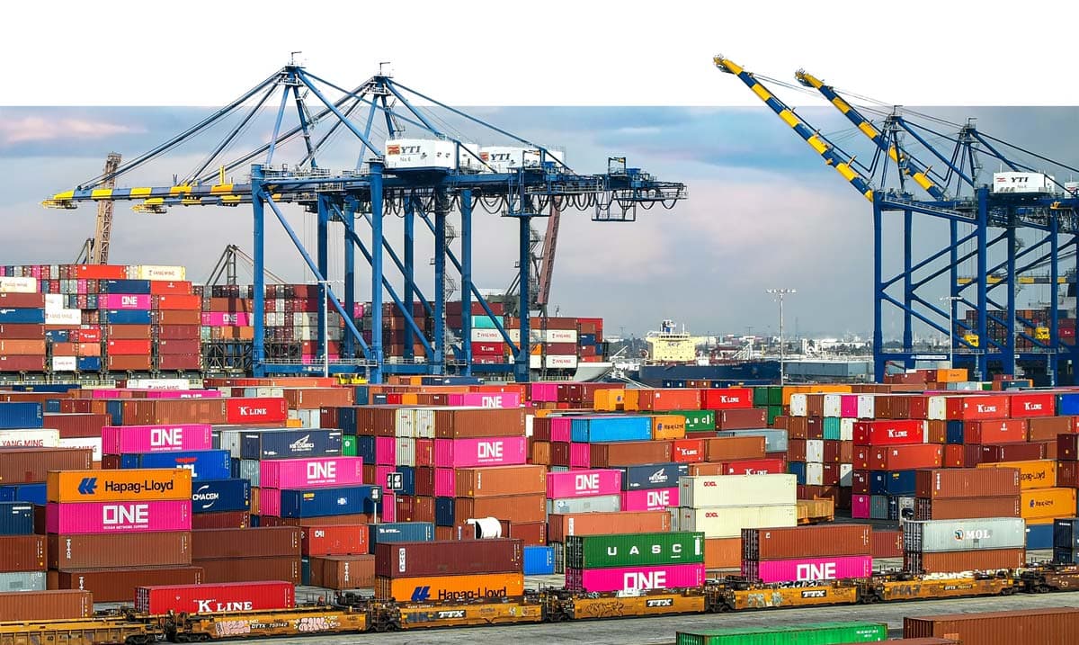 Das Bild zeigt einen Containerhafen mit Ladekränen.