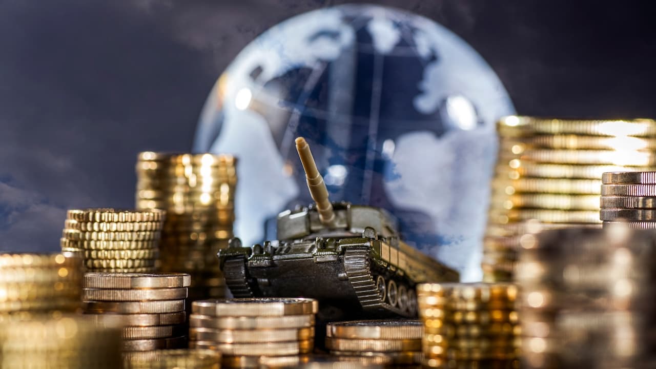 Geldstapel und Panzer vor einem Globus